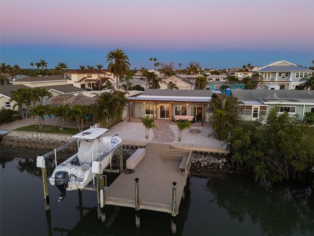 17730 Long Point Dr, Redington Shores, FL 33708 - back of property at dusk featuring a residential view, a patio, a water view, and boat lift