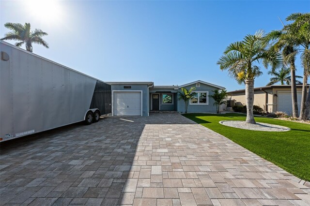 17730 Long Point Dr, Redington Shores, FL 33708 - view of front of home featuring a garage, stucco siding, a front yard, and decorative driveway