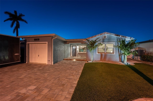 17730 Long Point Dr, Redington Shores, FL 33708 - ranch-style home featuring stucco siding, a front lawn, decorative driveway, and a garage