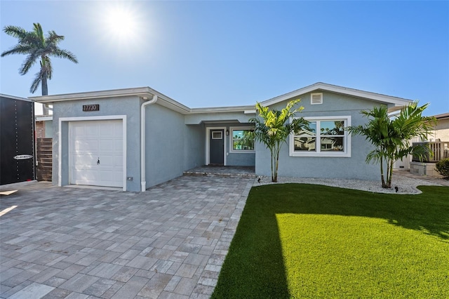 17730 Long Point Dr, Redington Shores, FL 33708 - single story home with an attached garage, a front yard, and stucco siding