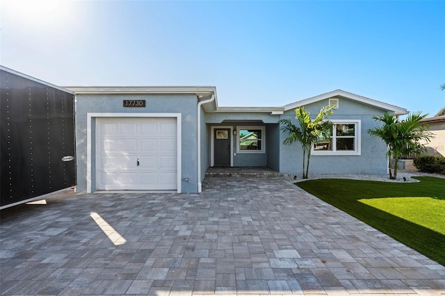 17730 Long Point Dr, Redington Shores, FL 33708 - ranch-style home featuring a garage, driveway, a front yard, and stucco siding