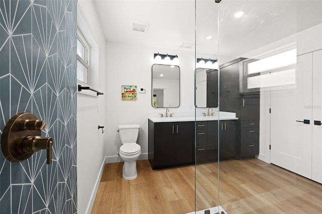17730 Long Point Dr, Redington Shores, FL 33708 - bathroom featuring toilet, wood finished floors, double vanity, and a sink