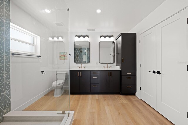 17730 Long Point Dr, Redington Shores, FL 33708 - full bathroom featuring wood finished floors, a sink, double vanity, and toilet