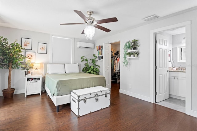 bedroom featuring a wall mounted AC, visible vents, a walk in closet, baseboards, and wood finished floors