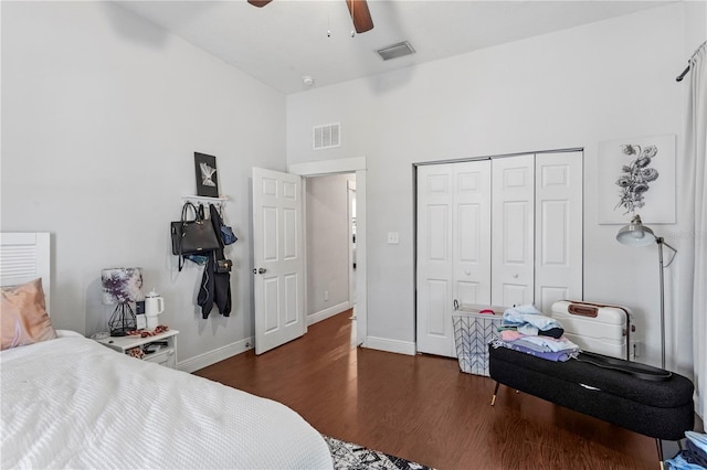 bedroom with a closet, visible vents, wood finished floors, and baseboards