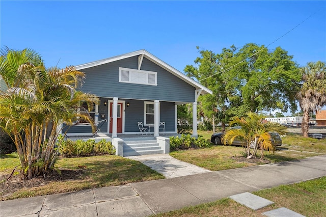 bungalow-style house featuring a front lawn and covered porch