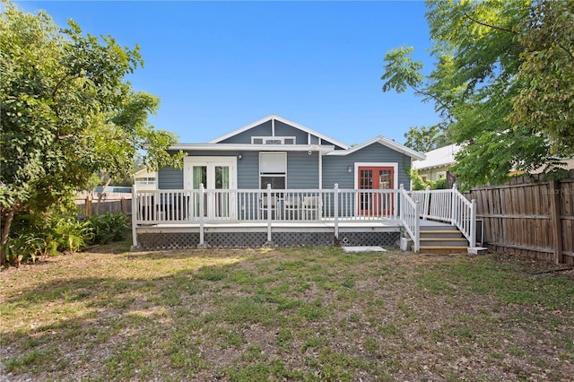 rear view of house with a wooden deck, french doors, and a fenced backyard