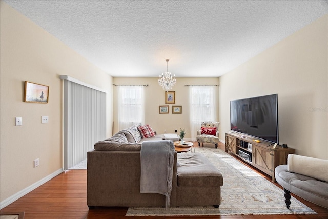 1227 Ballard Green Pl, Brandon, FL 33511 - living room featuring plenty of natural light, baseboards, wood finished floors, and an inviting chandelier
