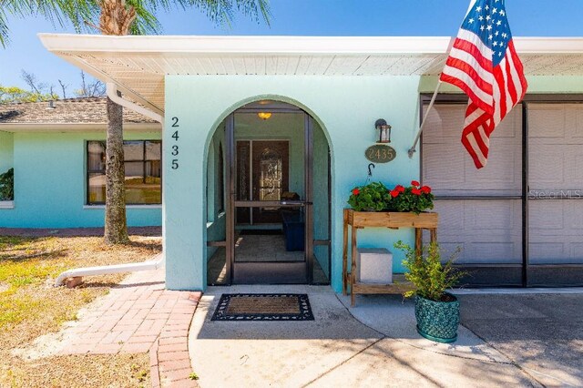 2435 Comerwood Dr, Spring Hill, FL 34609 - entrance to property with stucco siding and a shingled roof
