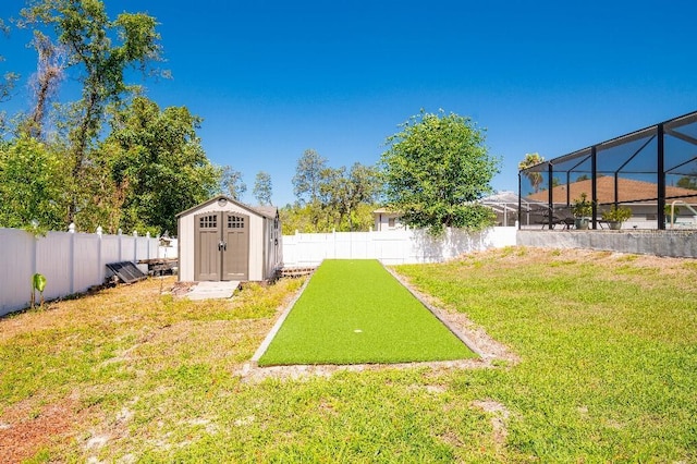 2435 Comerwood Dr, Spring Hill, FL 34609 - view of yard with glass enclosure, a storage unit, an outbuilding, and a fenced backyard