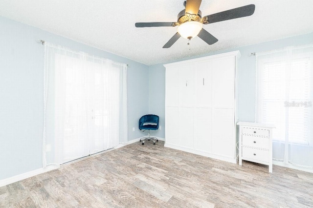 2435 Comerwood Dr, Spring Hill, FL 34609 - unfurnished bedroom with ceiling fan, baseboards, and wood finished floors