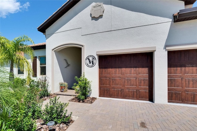 17583 Holly Well Ave, Wimauma, FL 33598 - view of front of house with stucco siding, decorative driveway, and a garage
