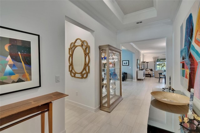 17583 Holly Well Ave, Wimauma, FL 33598 - corridor featuring baseboards, ornamental molding, a tray ceiling, and visible vents