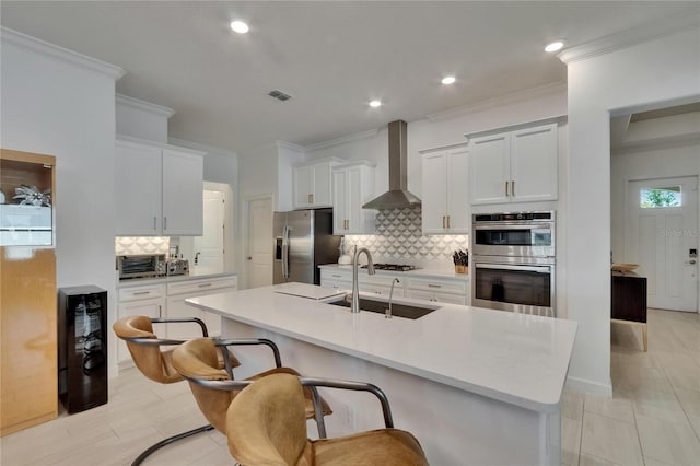 17583 Holly Well Ave, Wimauma, FL 33598 - kitchen featuring beverage cooler, stainless steel appliances, a sink, wall chimney exhaust hood, and decorative backsplash