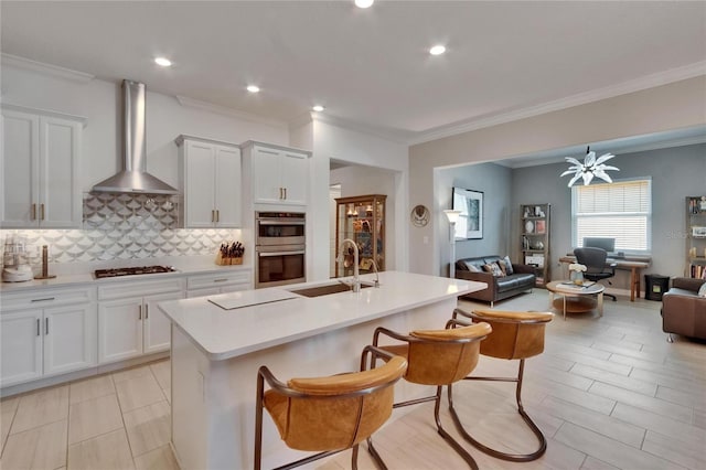 17583 Holly Well Ave, Wimauma, FL 33598 - kitchen featuring wall chimney range hood, a sink, open floor plan, stainless steel double oven, and gas stovetop