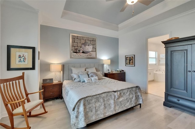 17583 Holly Well Ave, Wimauma, FL 33598 - bedroom with ensuite bath, ornamental molding, a tray ceiling, and light wood-type flooring