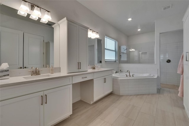 17583 Holly Well Ave, Wimauma, FL 33598 - full bath with a garden tub, visible vents, a sink, and a walk in shower