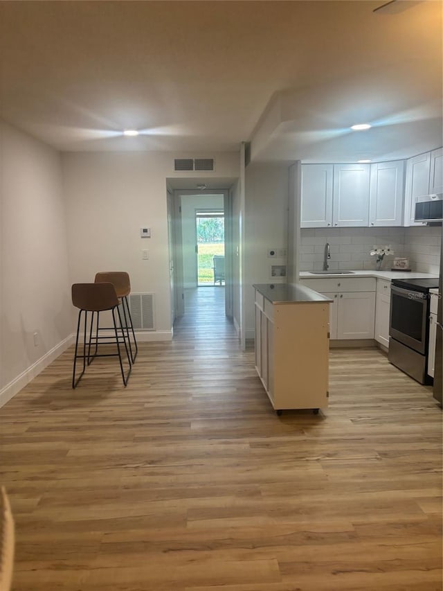 24862 US Highway 19 N Unit 2303, Clearwater, FL 33763 - kitchen featuring appliances with stainless steel finishes, a sink, white cabinets, and light wood-style flooring