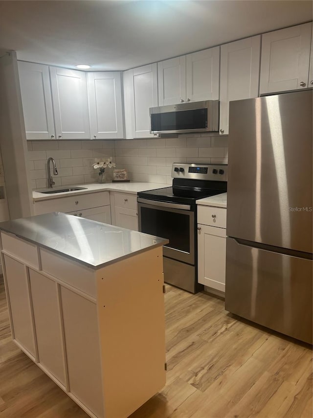 24862 US Highway 19 N Unit 2303, Clearwater, FL 33763 - kitchen with stainless steel appliances, a sink, light wood finished floors, tasteful backsplash, and a kitchen island