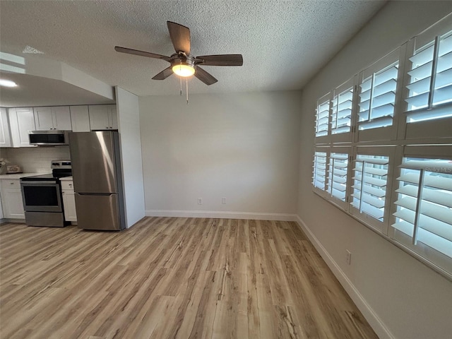 24862 US Highway 19 N Unit 2303, Clearwater, FL 33763 - kitchen featuring appliances with stainless steel finishes, a textured ceiling, light wood-style floors, white cabinets, and a ceiling fan
