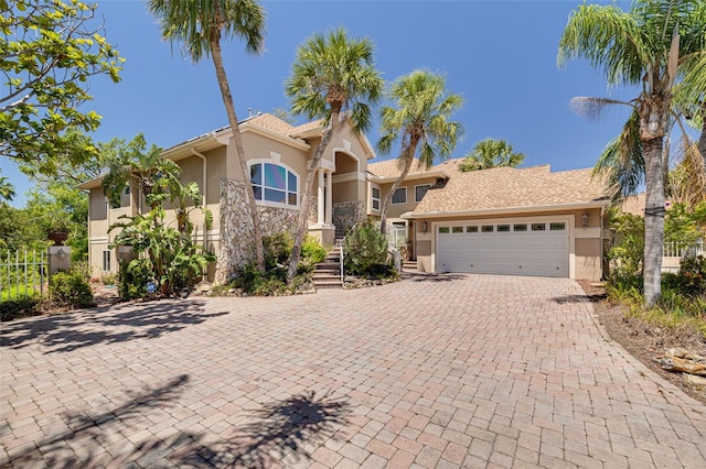 2613 59th St S, Gulfport, FL 33707 - mediterranean / spanish house featuring stucco siding, a garage, and decorative driveway