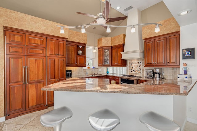 2613 59th St S, Gulfport, FL 33707 - kitchen with a peninsula, tasteful backsplash, ceiling fan, light stone countertops, and a kitchen bar