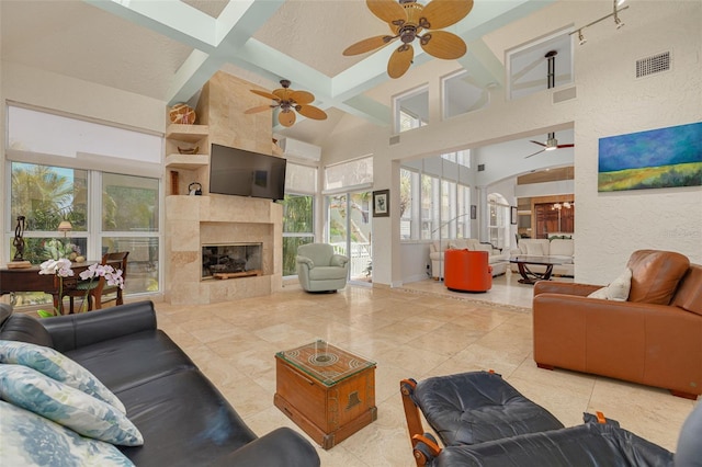 2613 59th St S, Gulfport, FL 33707 - living room featuring ceiling fan, beam ceiling, a fireplace, high vaulted ceiling, and tile patterned floors