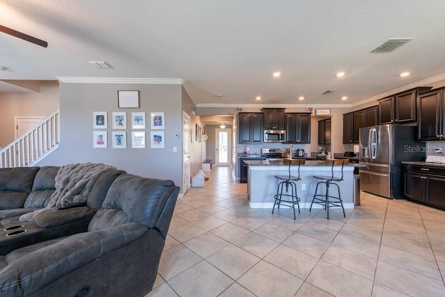 kitchen featuring visible vents, light tile patterned floors, appliances with stainless steel finishes, open floor plan, and a breakfast bar area