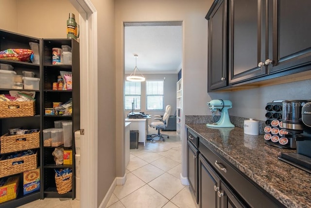 interior space with baseboards, crown molding, and light tile patterned floors