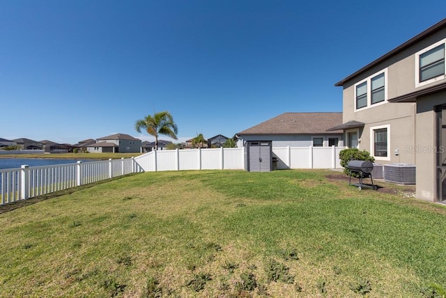view of yard with a fenced backyard, a water view, and a residential view