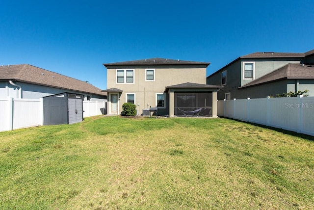 back of house featuring a fenced backyard, an outdoor structure, a lawn, a storage unit, and a sunroom