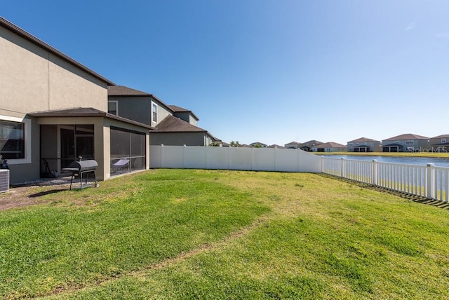 view of yard with a residential view, a fenced backyard, and a water view