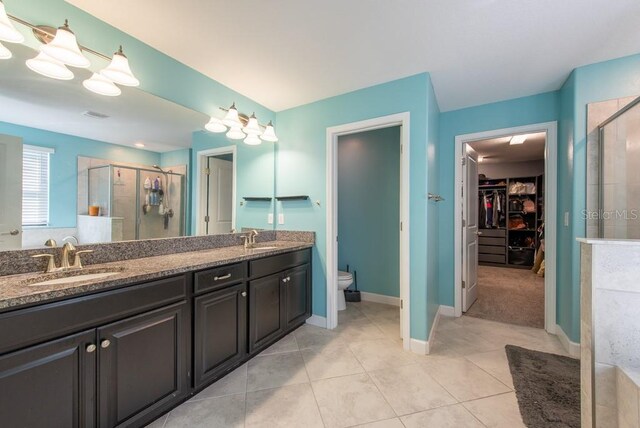 13639 Ashlar Slate Pl, Riverview, FL 33579 - full bathroom with a walk in closet, a stall shower, double vanity, and tile patterned floors