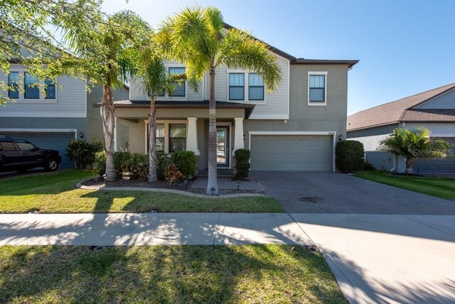13639 Ashlar Slate Pl, Riverview, FL 33579 - view of front of house featuring stucco siding, a garage, a front lawn, and driveway
