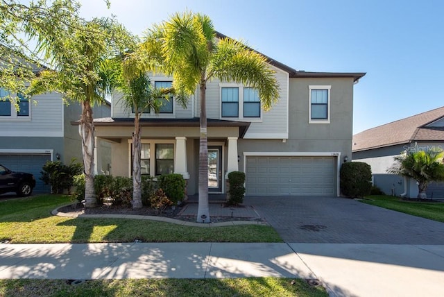 13639 Ashlar Slate Pl, Riverview, FL 33579 - view of front of house with stucco siding, decorative driveway, an attached garage, and a porch