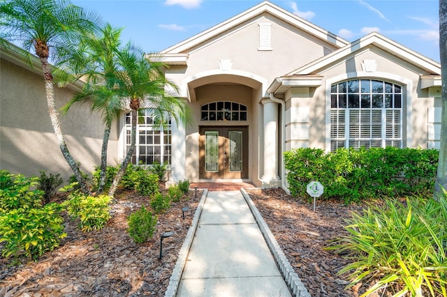 entrance to property featuring stucco siding and french doors