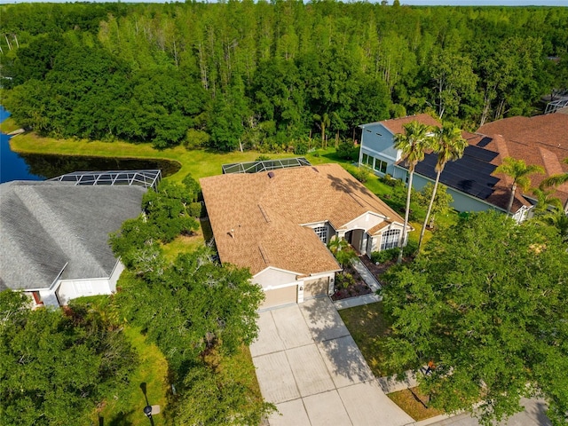 birds eye view of property with a wooded view and a water view