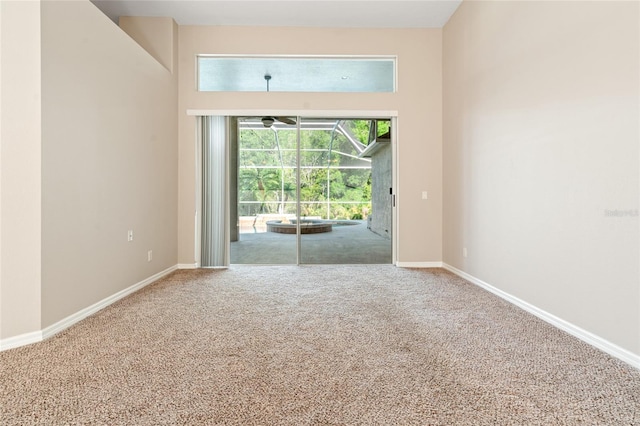 spare room featuring carpet and baseboards