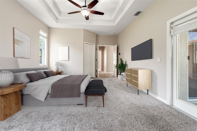 carpeted bedroom featuring ceiling fan, visible vents, access to outside, and a raised ceiling