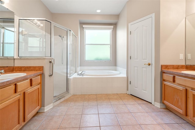 bathroom with two vanities, a sink, a stall shower, tile patterned flooring, and a garden tub