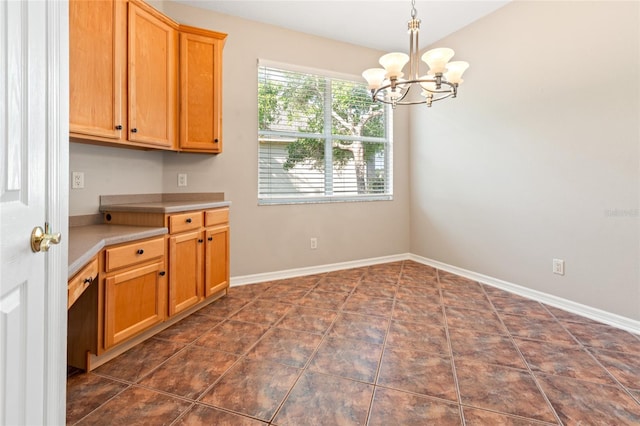 unfurnished dining area featuring baseboards and a notable chandelier