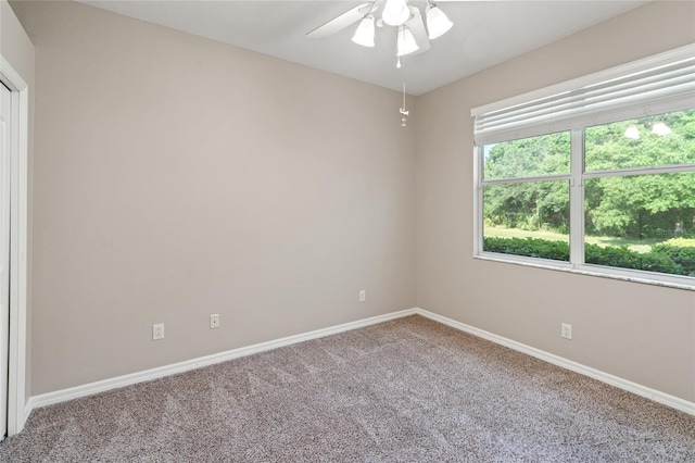 empty room with carpet flooring, baseboards, and a ceiling fan