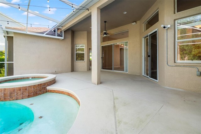 view of swimming pool with a patio, a ceiling fan, and an in ground hot tub