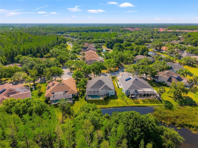 drone / aerial view featuring a residential view, a forest view, and a water view