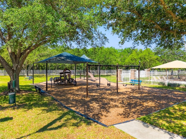community play area featuring fence and a yard