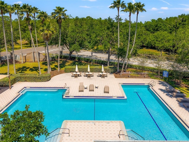 community pool with fence and a patio