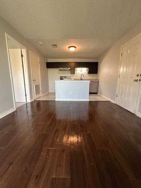 unfurnished living room featuring baseboards, wood finished floors, a textured ceiling, and a sink