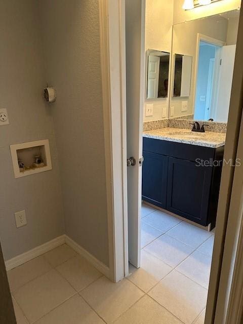 bathroom featuring baseboards, tile patterned flooring, and vanity