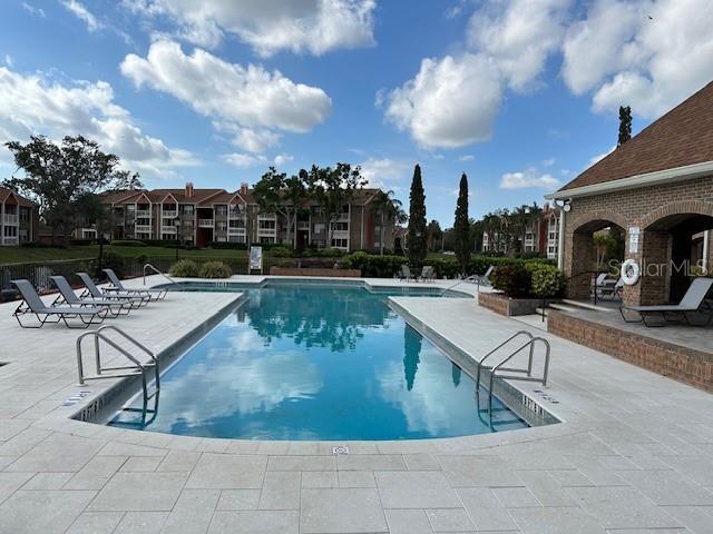pool with a patio area and a residential view