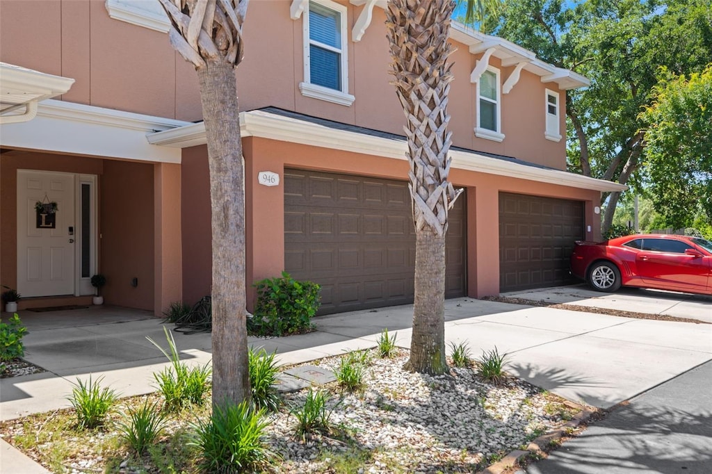 view of property featuring stucco siding, driveway, and a garage